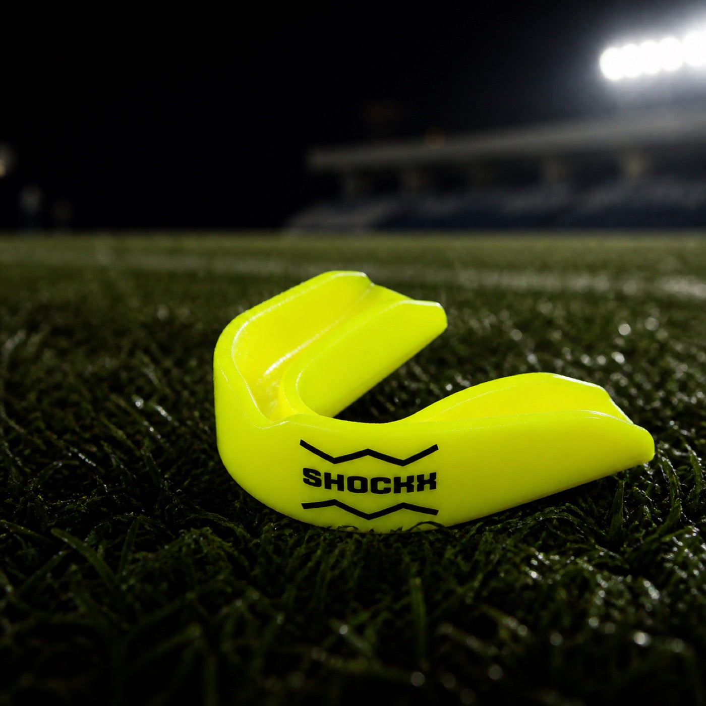 Geel Shockx bitje op het rugbyveld onder stadionverlichting